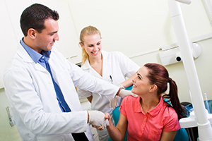 woman shaking hands with male dentist and assistant, West Hollywood, CA cosmetic dentistry